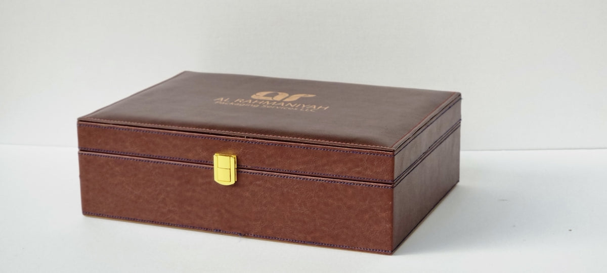 A brown leather box with a gold clasp on white.